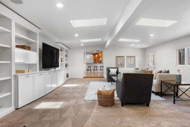 living room featuring recessed lighting, a skylight, and light colored carpet