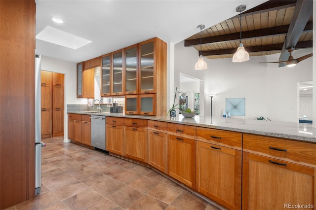 kitchen featuring beamed ceiling, light stone countertops, a sink, stainless steel dishwasher, and a skylight