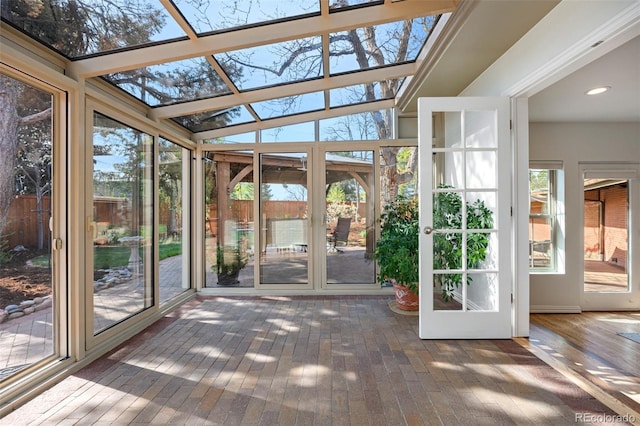unfurnished sunroom featuring plenty of natural light, a skylight, french doors, and hardwood / wood-style flooring