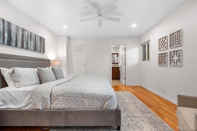 bedroom with recessed lighting, baseboards, light wood finished floors, and ensuite bath