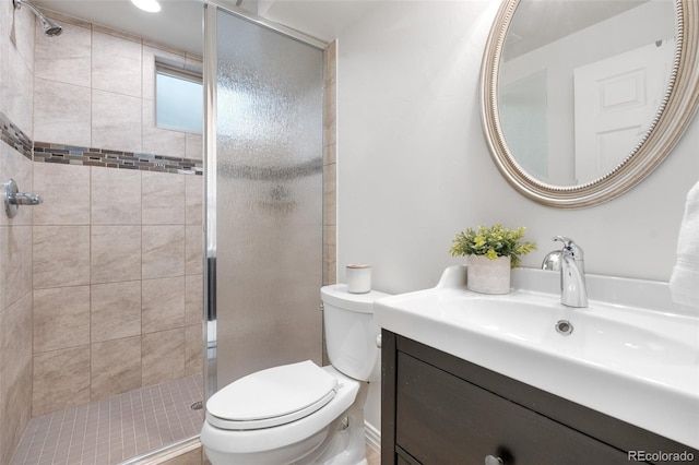 bathroom featuring vanity, toilet, and a shower stall