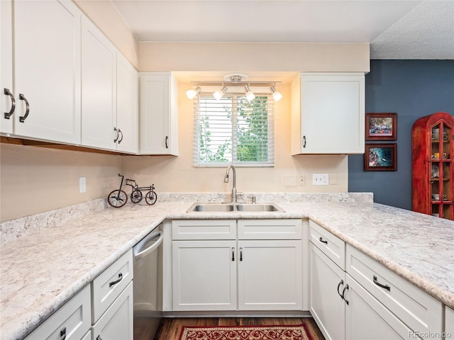 kitchen with white cabinets, dishwasher, light countertops, and a sink