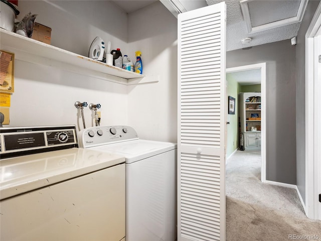 washroom featuring a textured ceiling, washing machine and dryer, and light colored carpet