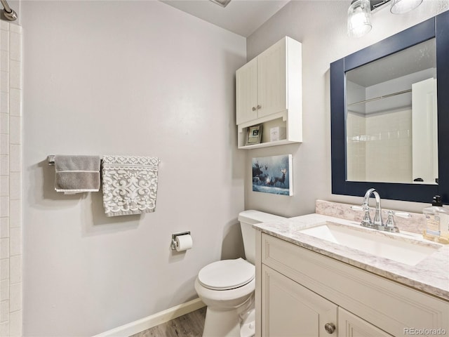 bathroom with wood-type flooring, walk in shower, vanity, and toilet