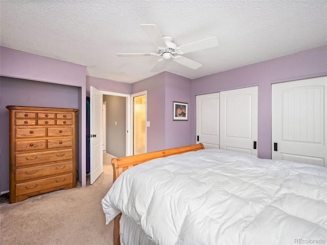 bedroom featuring a textured ceiling, light carpet, and ceiling fan