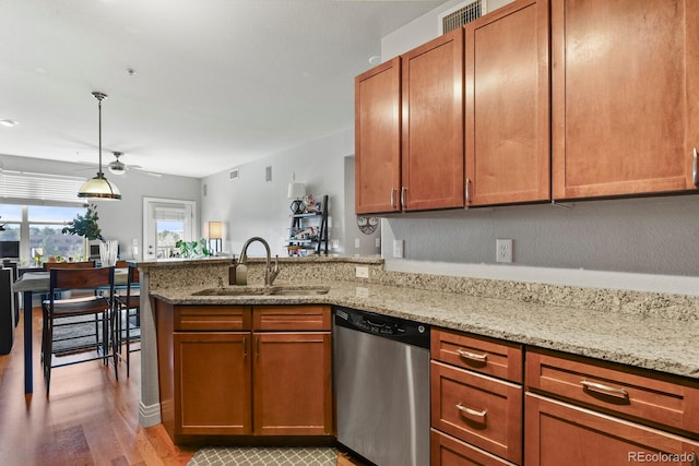 kitchen featuring light stone countertops, dishwasher, a peninsula, a ceiling fan, and a sink