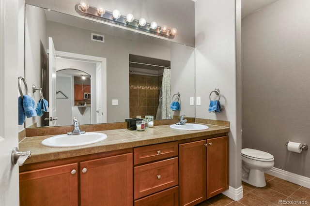 full bath with a sink, baseboards, toilet, and tile patterned flooring