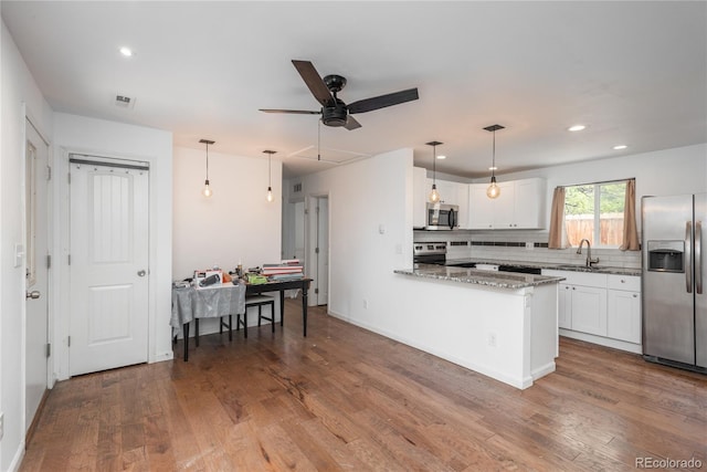 3629 W Custer Pl, Denver, CO 80219 - kitchen featuring stainless steel appliances, a sink, white cabinetry, wood finished floors, and recessed lighting