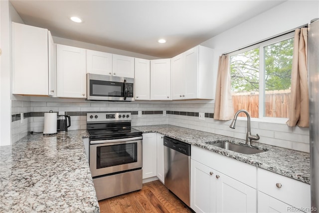 3629 W Custer Pl, Denver, CO 80219 - kitchen with appliances with stainless steel finishes, a sink, backsplash, white cabinetry, and recessed lighting
