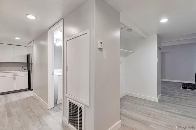 corridor with washer / dryer and light hardwood / wood-style flooring