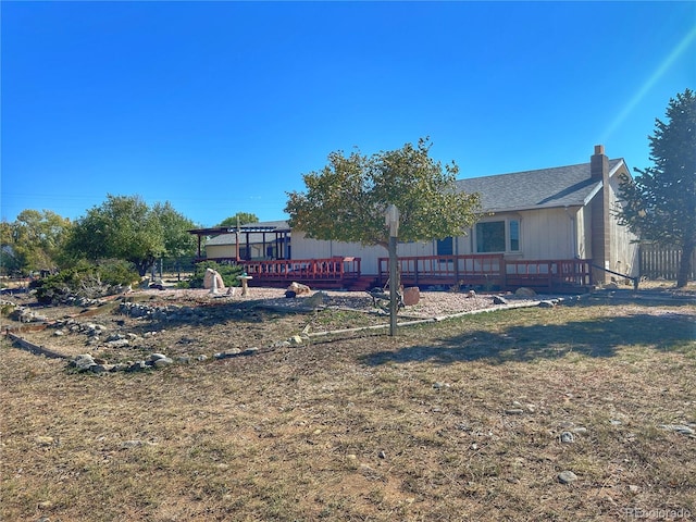 rear view of property with a yard and a wooden deck