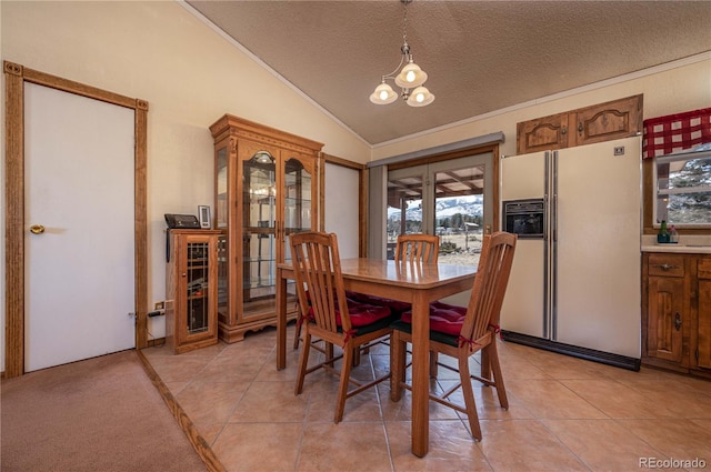 dining room with light tile patterned flooring, vaulted ceiling, an inviting chandelier, and a textured ceiling