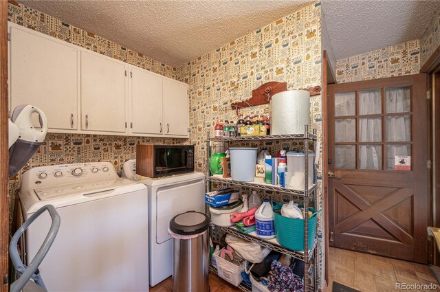 washroom featuring dark parquet flooring, washing machine and dryer, cabinets, and a textured ceiling