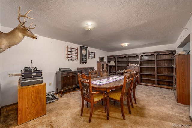 dining area with a textured ceiling and carpet flooring