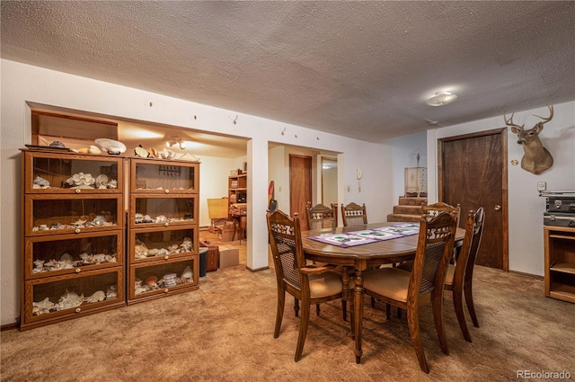 carpeted dining room featuring a textured ceiling