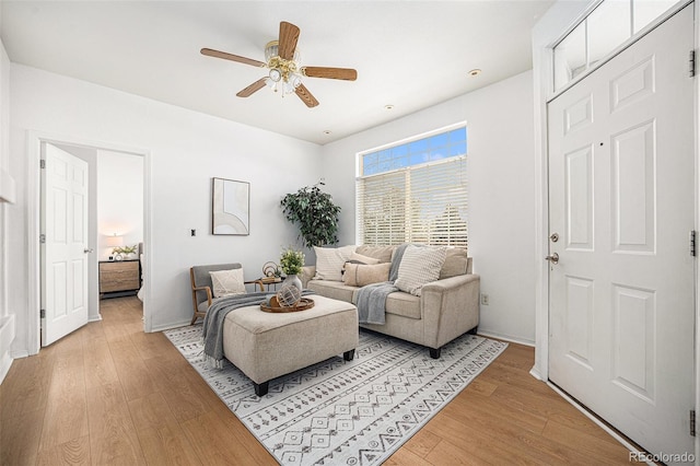 living room with ceiling fan and light hardwood / wood-style flooring