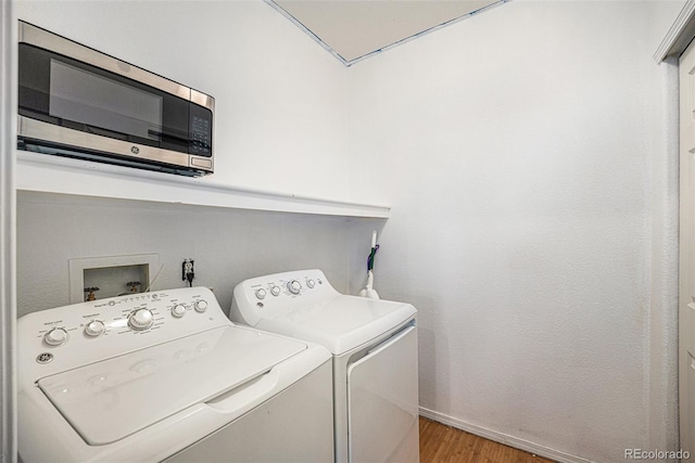 washroom featuring light hardwood / wood-style floors and washing machine and clothes dryer