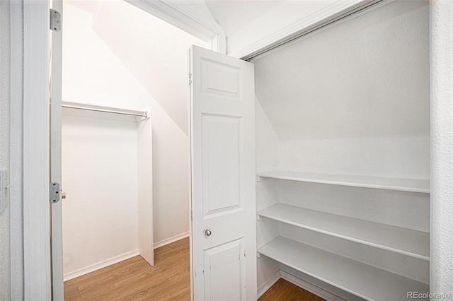 walk in closet featuring vaulted ceiling and hardwood / wood-style flooring