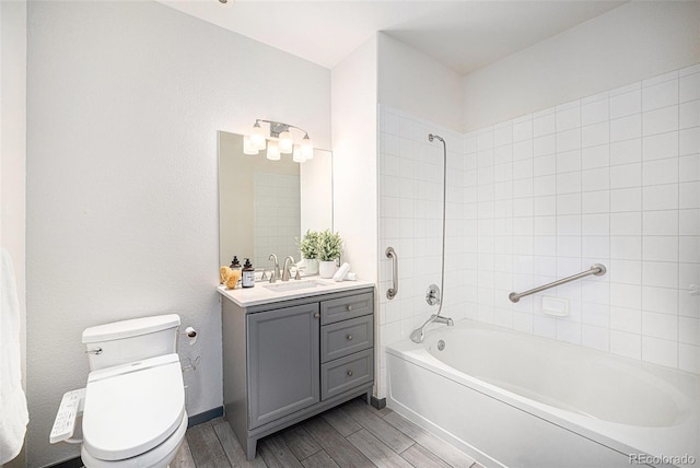 full bathroom with toilet, tiled shower / bath, and vanity