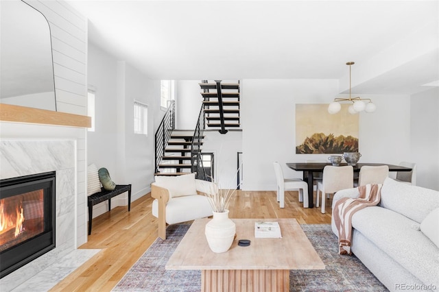 108 Arapahoe St, Golden, CO 80403 - living room featuring a tile fireplace, stairway, wood finished floors, a chandelier, and baseboards