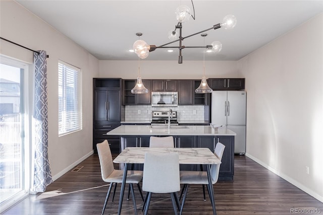 dining space featuring dark wood-type flooring, visible vents, and baseboards