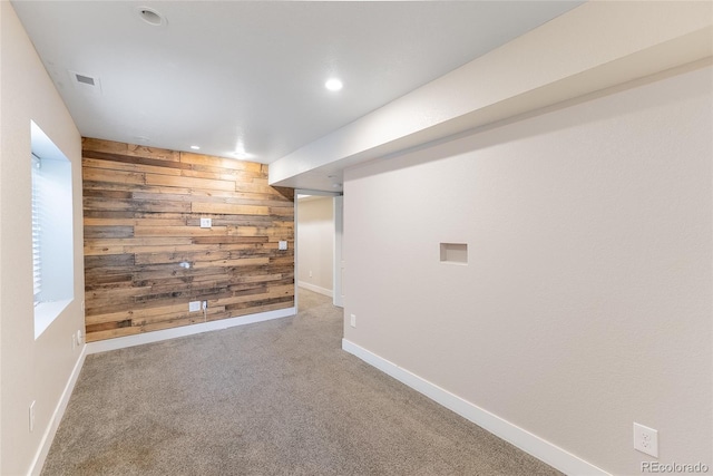 empty room with recessed lighting, wood walls, carpet flooring, visible vents, and baseboards