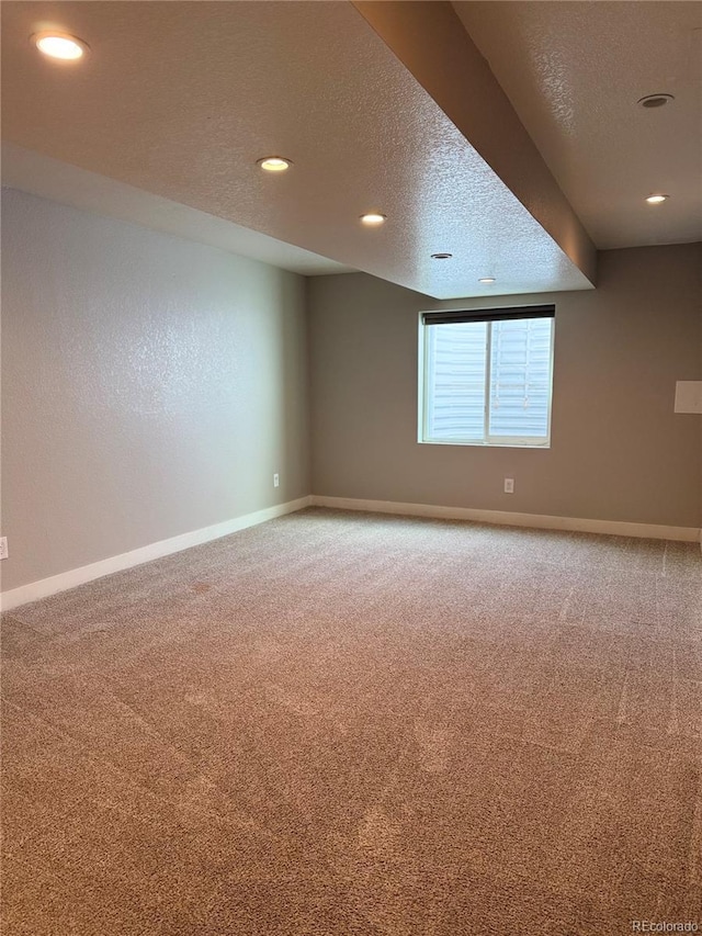 carpeted spare room featuring baseboards, a textured ceiling, and recessed lighting