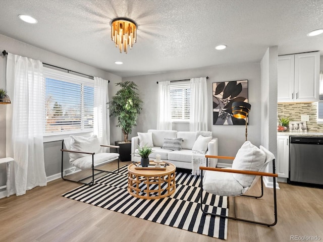 living room with a textured ceiling, light hardwood / wood-style flooring, and a wealth of natural light