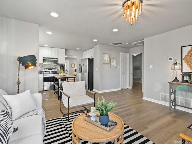 living room featuring dark wood-type flooring and a textured ceiling