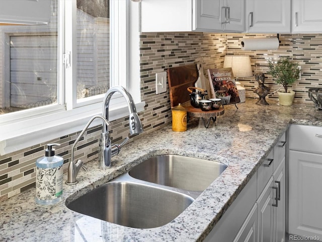 kitchen with sink, backsplash, and white cabinets