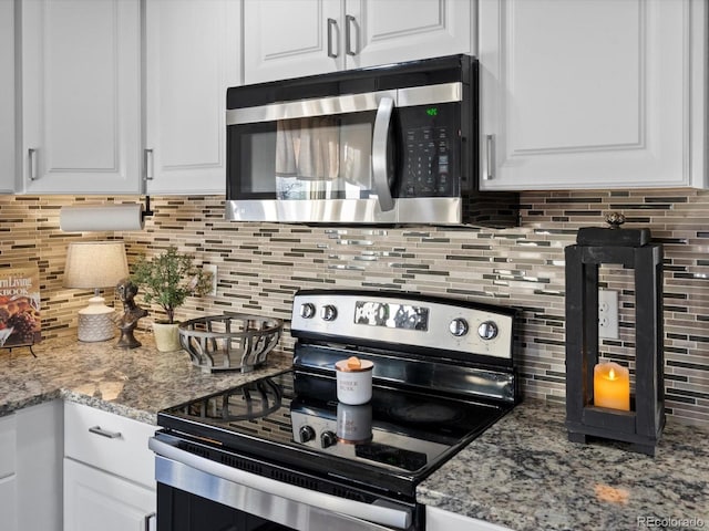 kitchen featuring light stone counters, stainless steel appliances, decorative backsplash, and white cabinets