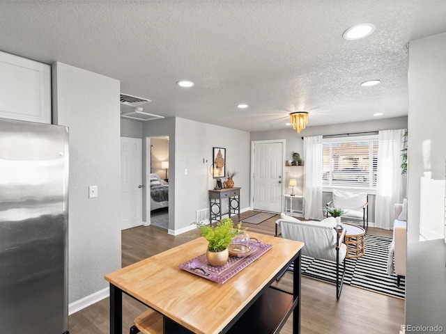 dining area with hardwood / wood-style flooring and a textured ceiling