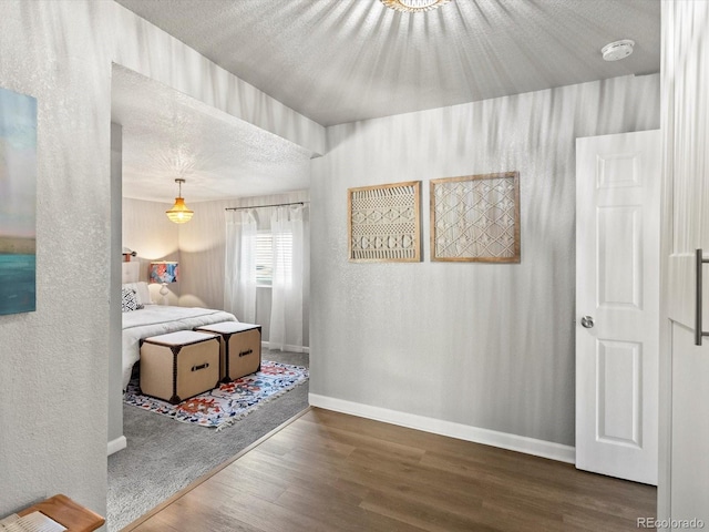 bedroom featuring wood-type flooring and a textured ceiling