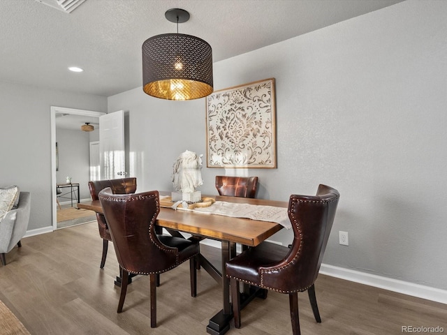 dining area featuring hardwood / wood-style flooring and a textured ceiling