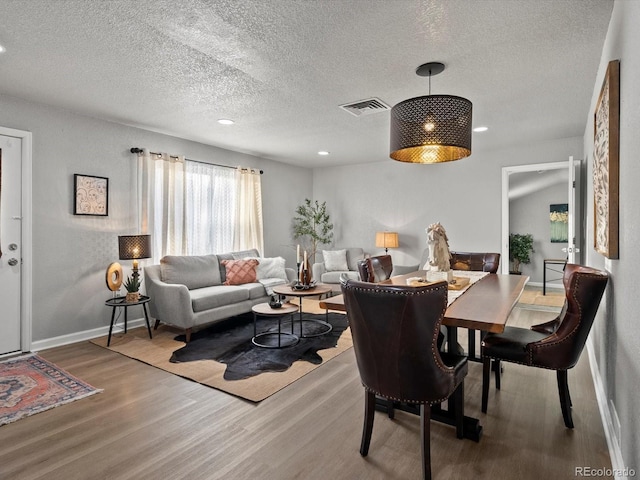 dining room with hardwood / wood-style flooring and a textured ceiling