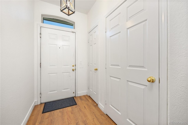 doorway to outside featuring light wood-style flooring and baseboards
