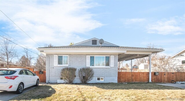 view of front of house with fence, brick siding, and a front yard