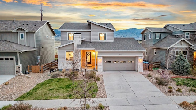 view of front of house featuring fence, a shingled roof, concrete driveway, an attached garage, and a mountain view