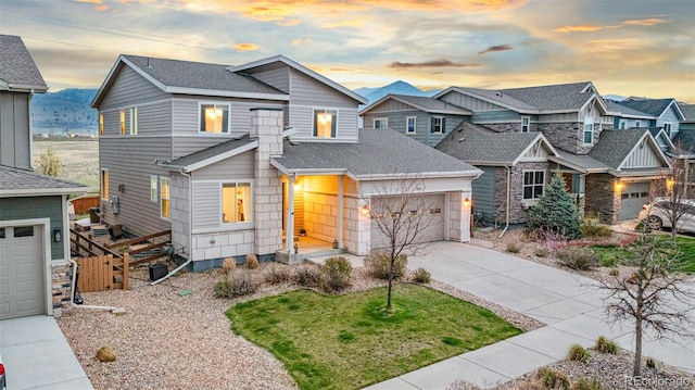 view of front facade featuring concrete driveway, an attached garage, fence, and a residential view