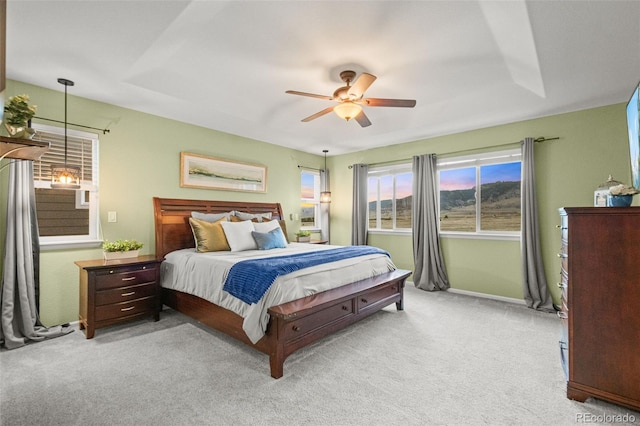 bedroom featuring ceiling fan, baseboards, light colored carpet, and multiple windows