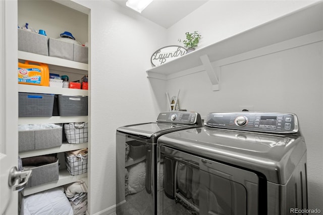 laundry room with marble finish floor, baseboards, washer and clothes dryer, and laundry area