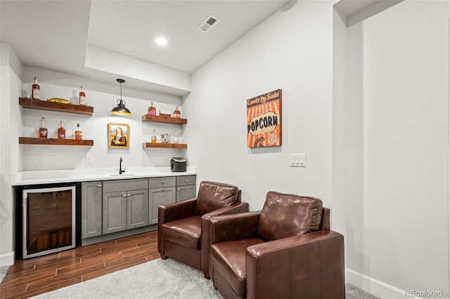 bar featuring a sink, baseboards, wet bar, dark wood-style flooring, and wine cooler