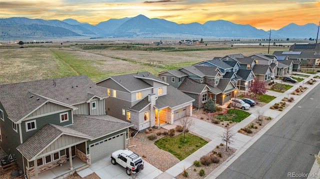 aerial view at dusk featuring a residential view and a mountain view
