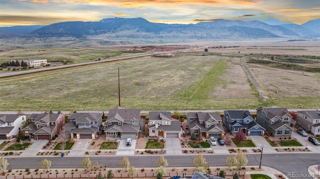 aerial view at dusk featuring a residential view and a mountain view