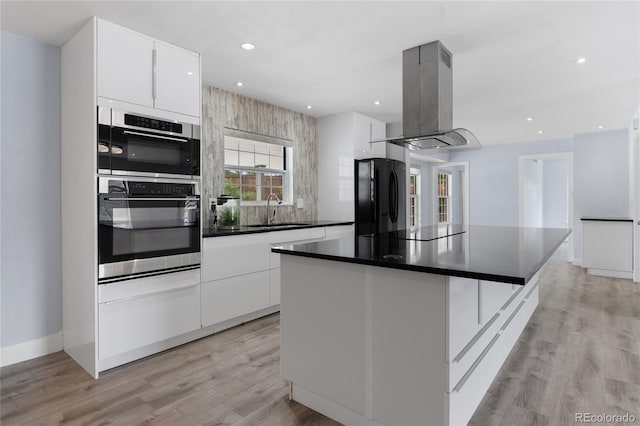 9451 W Hialeah Pl, Littleton, CO 80123 - kitchen with black appliances, island range hood, a sink, modern cabinets, and recessed lighting