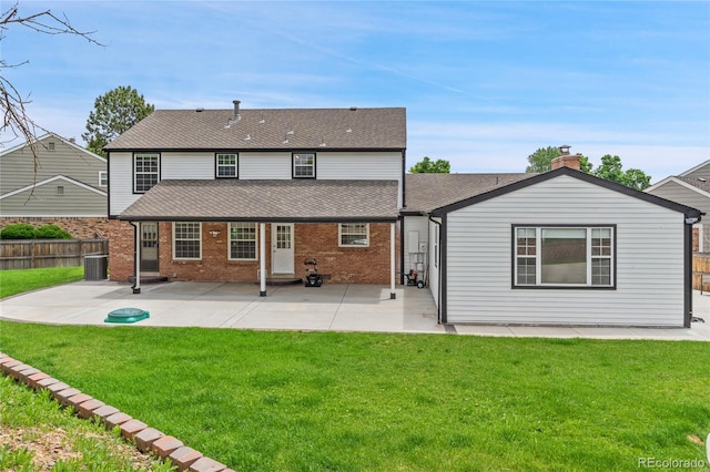 9451 W Hialeah Pl, Littleton, CO 80123 - back of property featuring a patio area, roof with shingles, brick siding, central AC, and a chimney