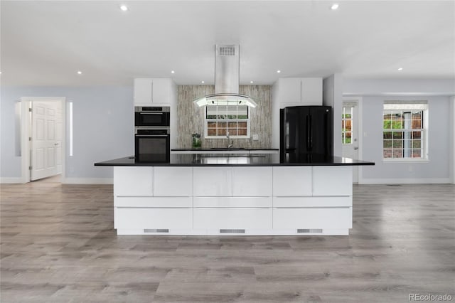 9451 W Hialeah Pl, Littleton, CO 80123 - kitchen featuring freestanding refrigerator, island range hood, white cabinets, baseboards, and recessed lighting