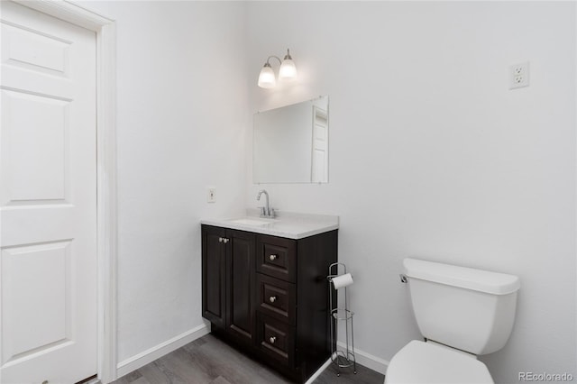 9451 W Hialeah Pl, Littleton, CO 80123 - half bath with wood finished floors, vanity, toilet, and baseboards