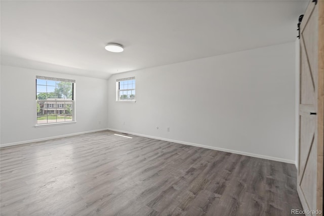 9451 W Hialeah Pl, Littleton, CO 80123 - empty room with a barn door, wood finished floors, and baseboards
