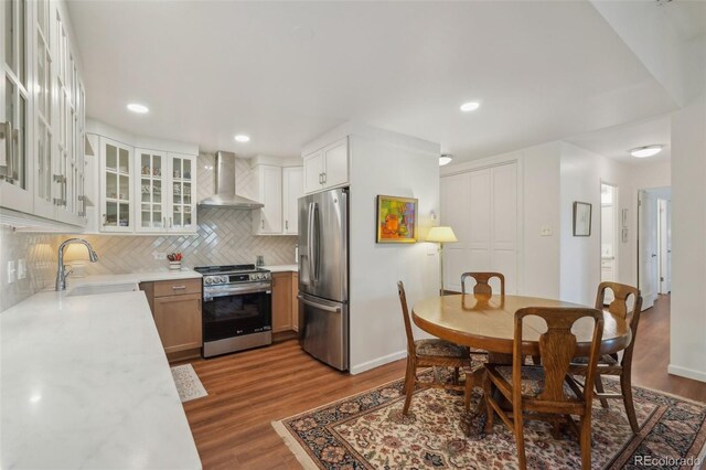 705 S Alton Way Unit 4D, Denver, CO 80247 - kitchen with appliances with stainless steel finishes, wall chimney exhaust hood, a sink, light countertops, and backsplash
